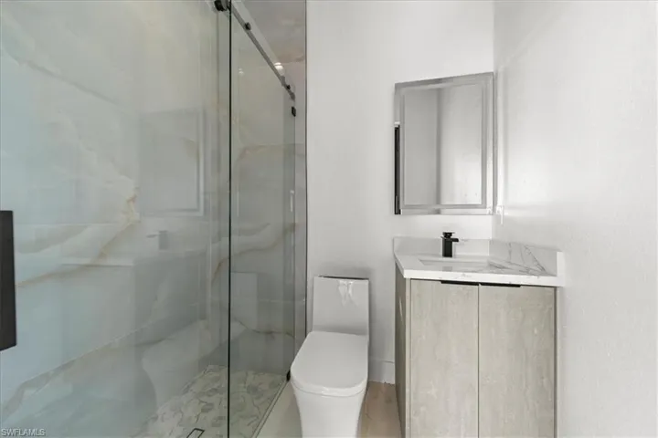 Full bathroom with a marble finish shower and vanity