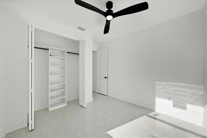 Unfurnished bedroom with a ceiling fan, a closet, and light tile patterned floors