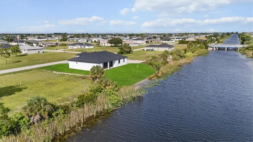 Aerial perspective of suburban area featuring a nearby body of water