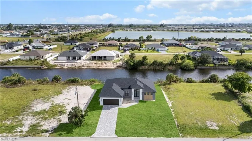 Aerial perspective of suburban area featuring a nearby body of water
