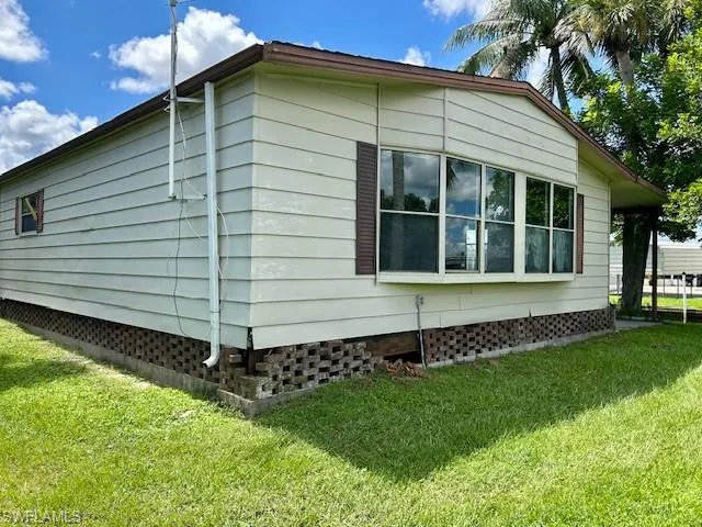 View of side of home with a lawn