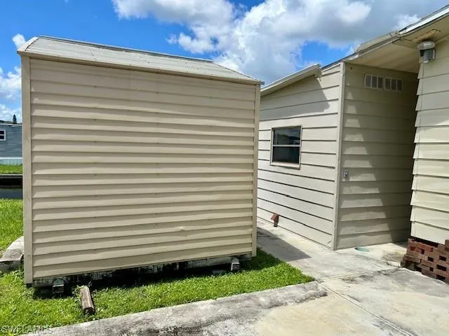 View of side of home featuring a shed