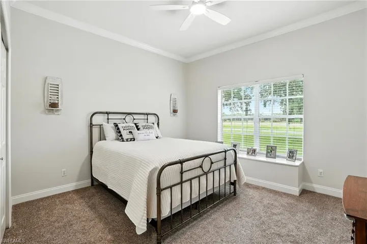 Bedroom featuring ornamental molding, carpet floors, and ceiling fan