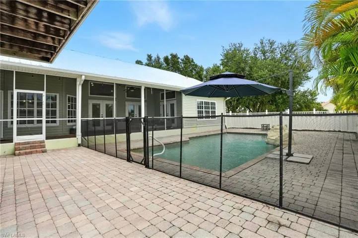 View of swimming pool with a patio area and a sunroom