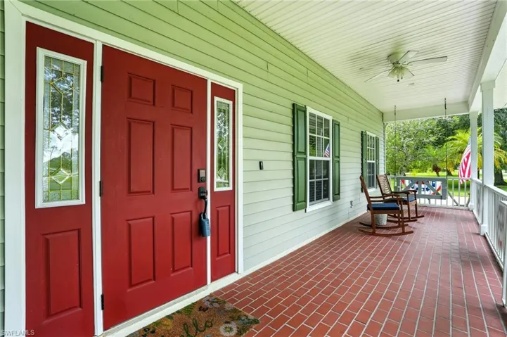 Property entrance with covered porch and ceiling fan
