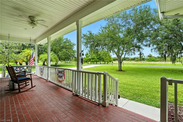 Porch with a ceiling fan and a yard