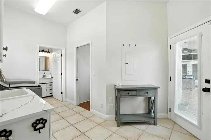Kitchen with light tile patterned floors, electric panel, and light stone countertops