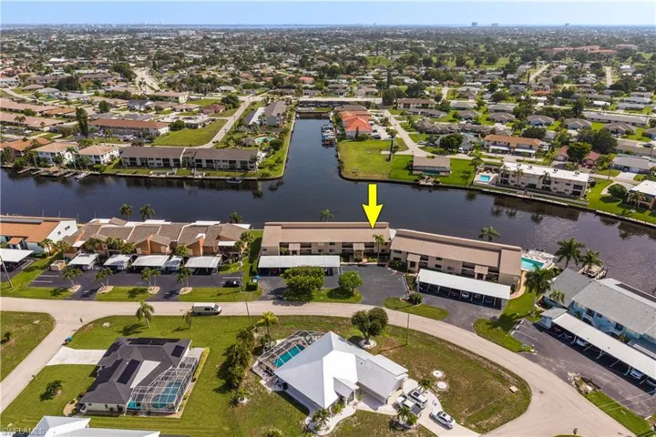 Waterfront condominium complex featuring multiple buildings with private boat dock access and covered parking