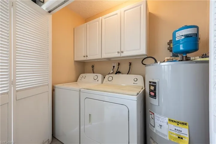 Dedicated laundry area featuring a water heater, washer, and dryer