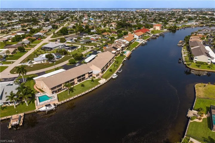 Waterfront condominium complex featuring a communal swimming pool and private boat docks