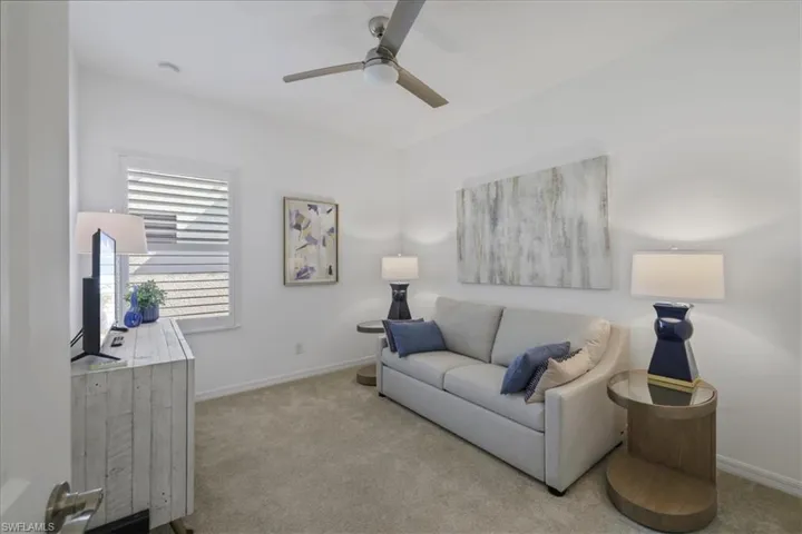 Living area featuring carpet floors and a ceiling fan
