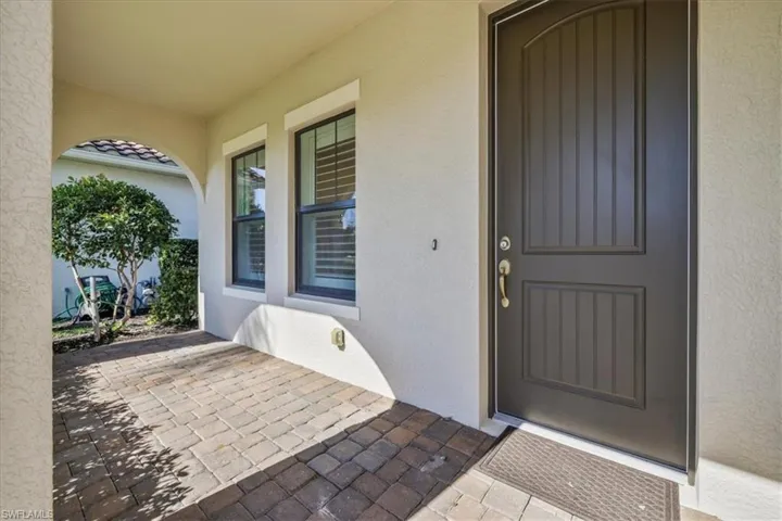 Property entrance with stucco siding and a patio