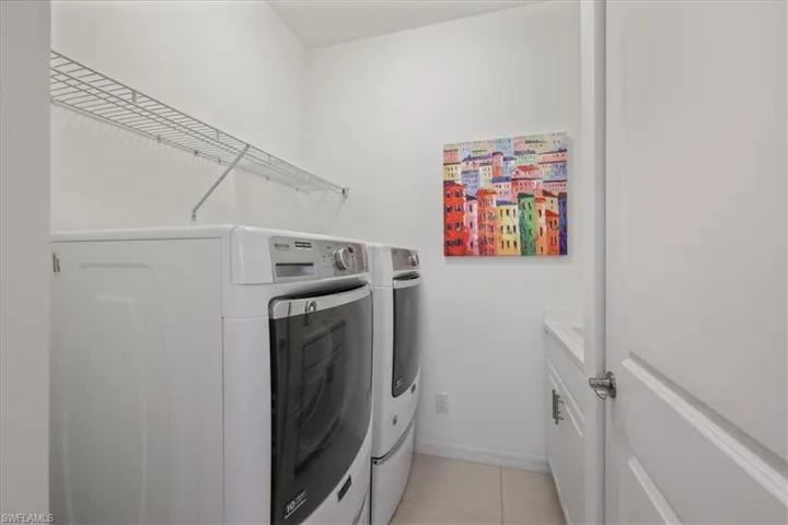 Laundry room featuring washer and clothes dryer and light tile patterned floors