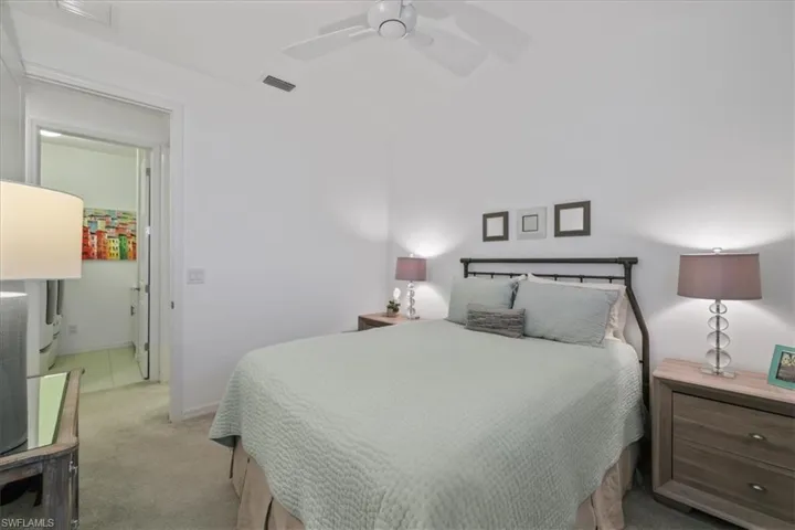 Bedroom with light carpet and a ceiling fan