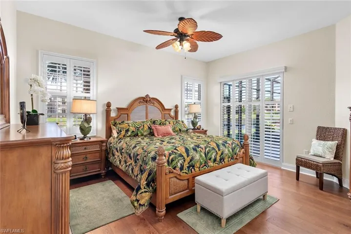 Bedroom with access to outside, multiple windows, hardwood / wood-style flooring, and ceiling fan