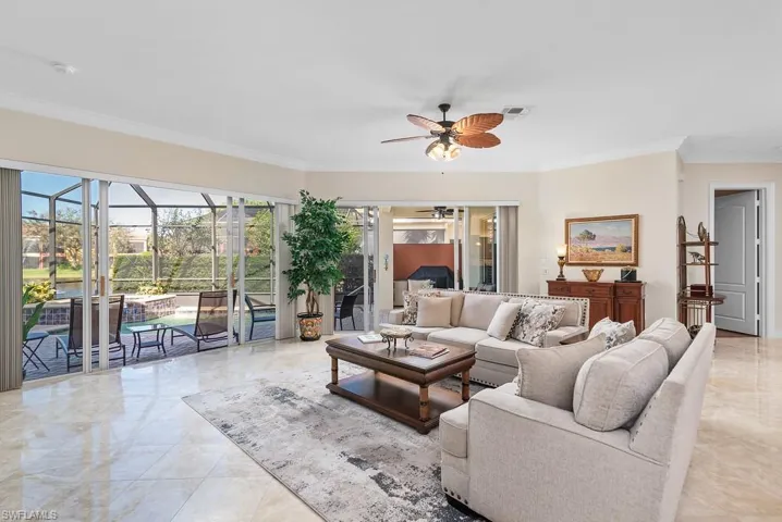 Living room featuring ornamental molding and ceiling fan