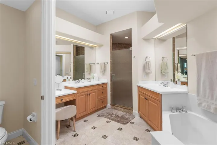 Full bathroom with toilet, vanity, tile patterned flooring, and separate shower and tub
