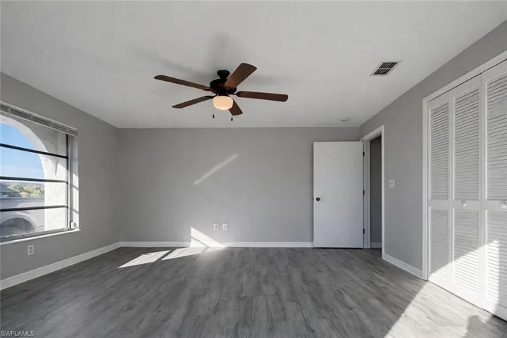 Unfurnished bedroom featuring a closet, wood finished floors, and ceiling fan