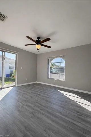 Unfurnished room with wood finished floors and a ceiling fan