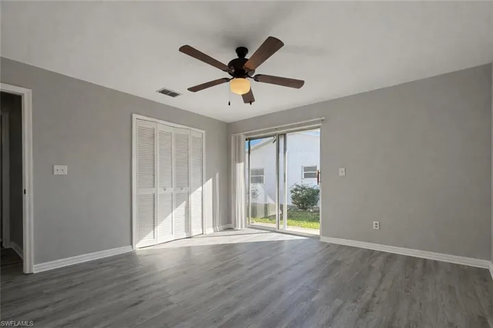 Unfurnished bedroom with wood finished floors, a closet, and a ceiling fan