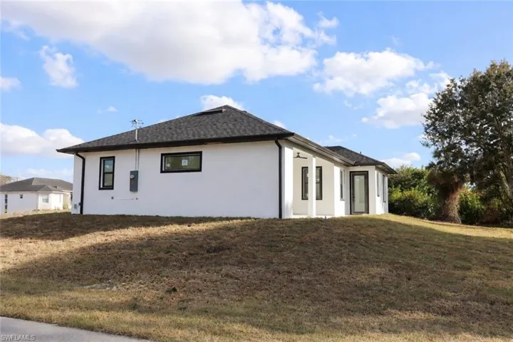 View of side of property with stucco siding and a lawn