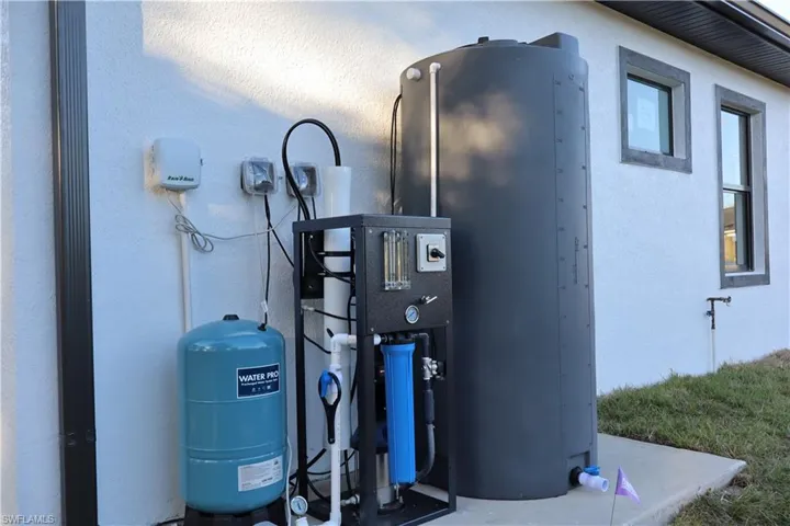 Exterior view of stucco siding and a water pressure tank