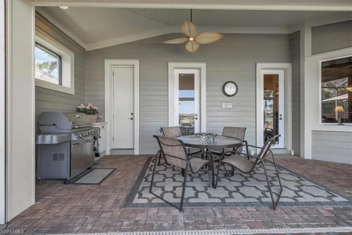 View of patio featuring outdoor dining space, area for grilling, and ceiling fan