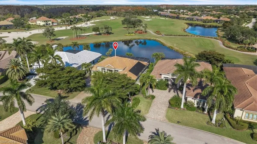 View of property location featuring nearby suburban area, a local golf course, and a nearby body of water