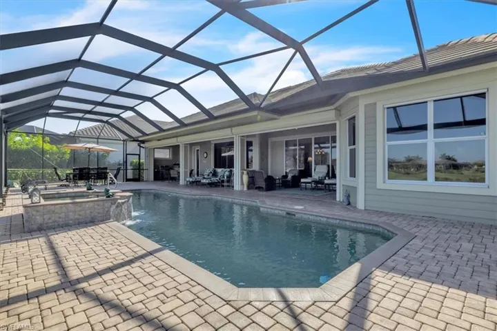 View of swimming pool featuring a patio area, a sunroom, a lanai, a pool with connected hot tub, and an outdoor hangout area