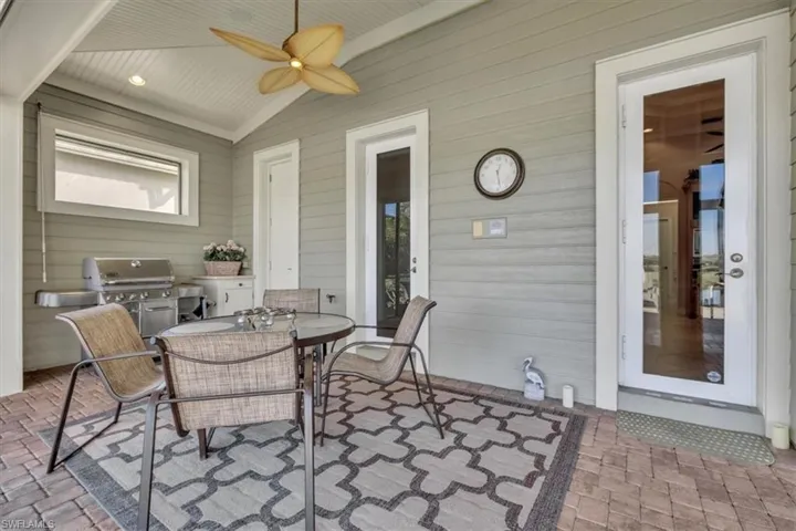 View of patio with outdoor dining space, a ceiling fan, and area for grilling