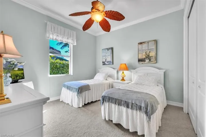 Bedroom with carpet floors, crown molding, a closet, and a ceiling fan