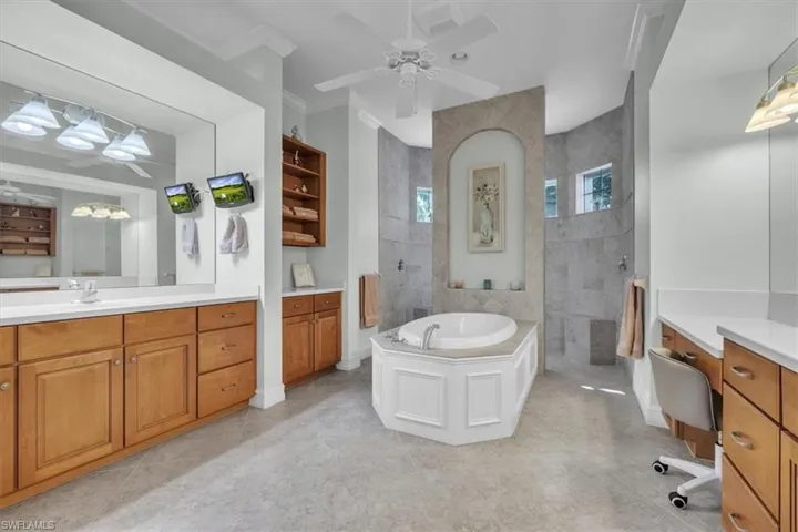 Full bath featuring a garden tub, a walk in shower, ceiling fan, and vanity
