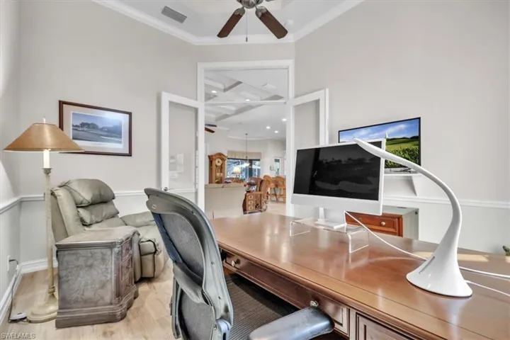 Office area with wood finished floors, a ceiling fan, and ornamental molding