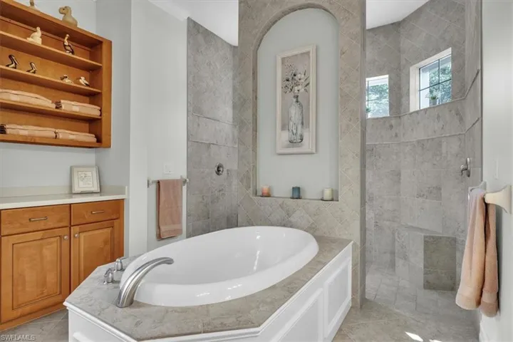 Full bathroom with a garden tub, tile walls, a walk in shower, and light tile patterned floors