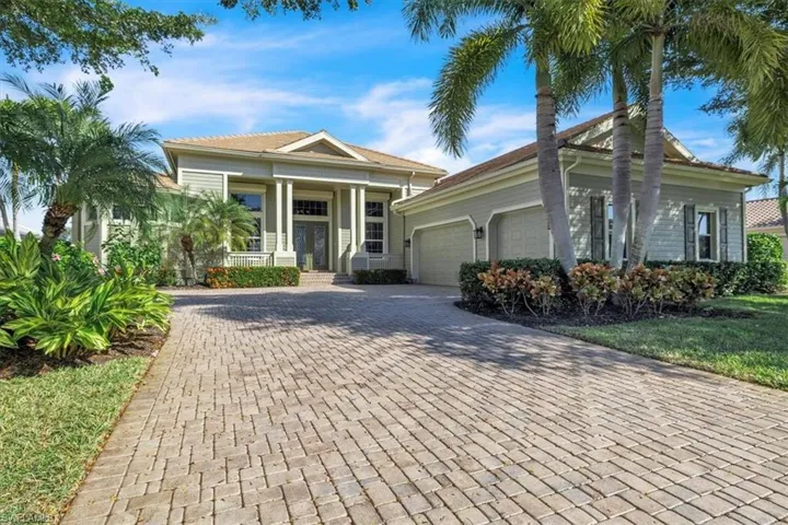 View of front of home featuring covered porch, decorative driveway, and a garage