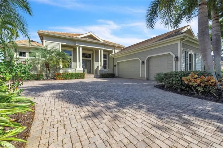 View of front facade featuring a porch, decorative driveway, and a garage