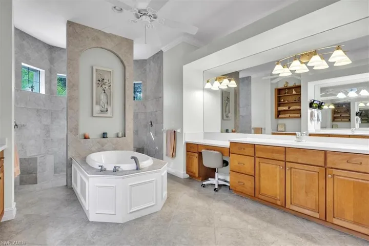 Full bath with a walk in shower, a bath, vanity, and a ceiling fan
