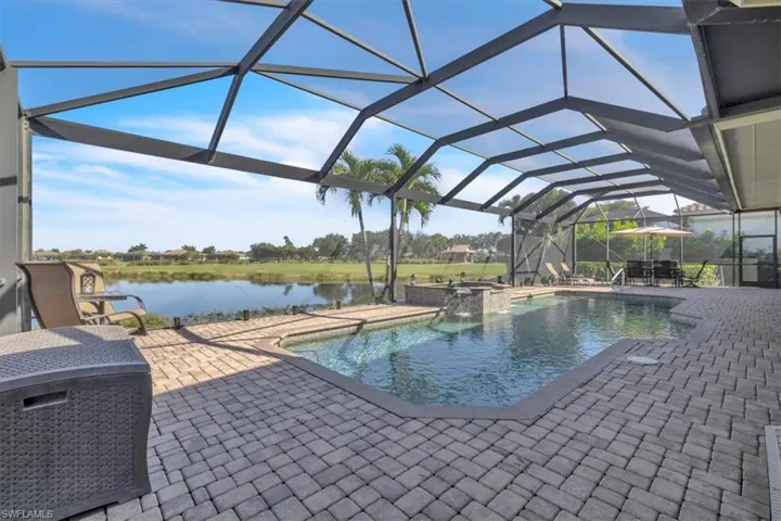 View of pool with a sunroom, a patio area, a lanai, and a water view