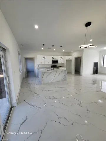 Unfurnished living room featuring baseboards and recessed lighting