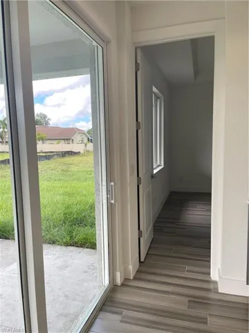 Corridor featuring baseboards and wood tiled floors