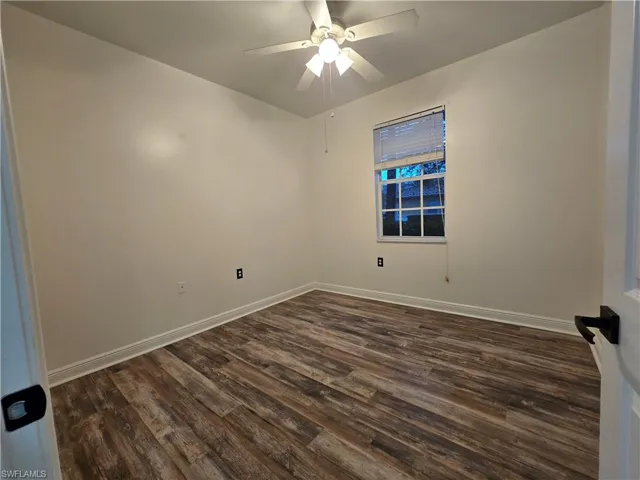 Spare room featuring ceiling fan and dark wood-type flooring
