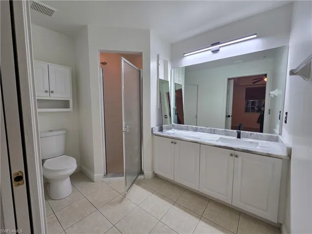 Bathroom with walk in shower, vanity, toilet, and tile patterned floors