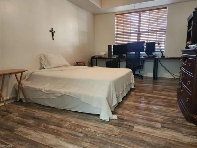 Bedroom with dark hardwood / wood-style flooring