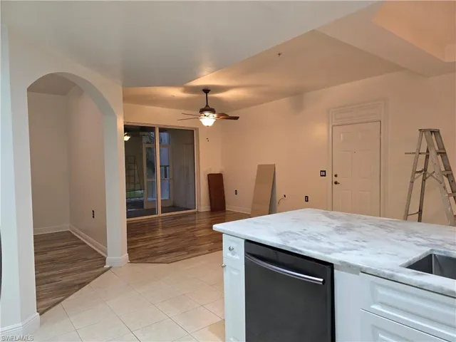 Kitchen featuring white cabinetry, ceiling fan, light hardwood / wood-style flooring, and light stone counters