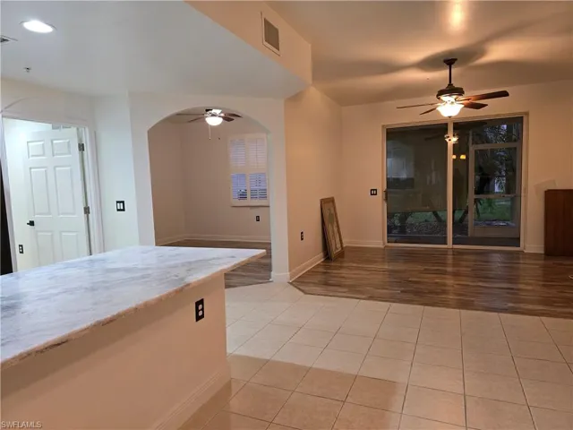 Kitchen with ceiling fan, light stone countertops, and light wood-type flooring