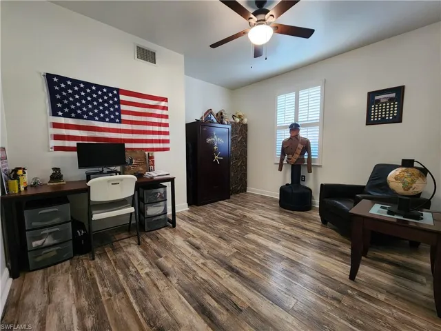 Home office featuring ceiling fan and dark hardwood / wood-style flooring