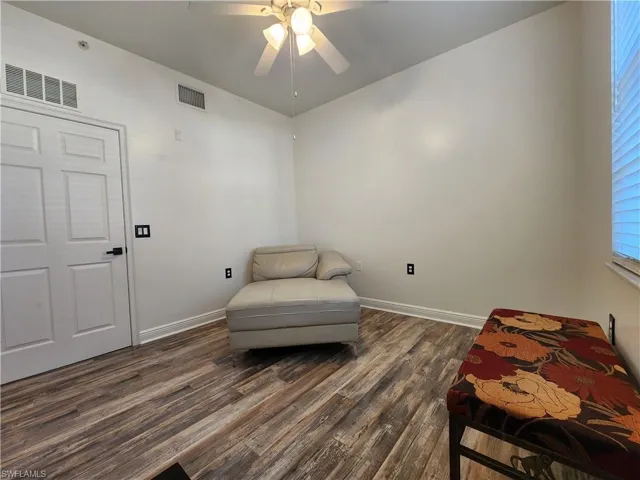 Sitting room with ceiling fan and dark hardwood / wood-style flooring