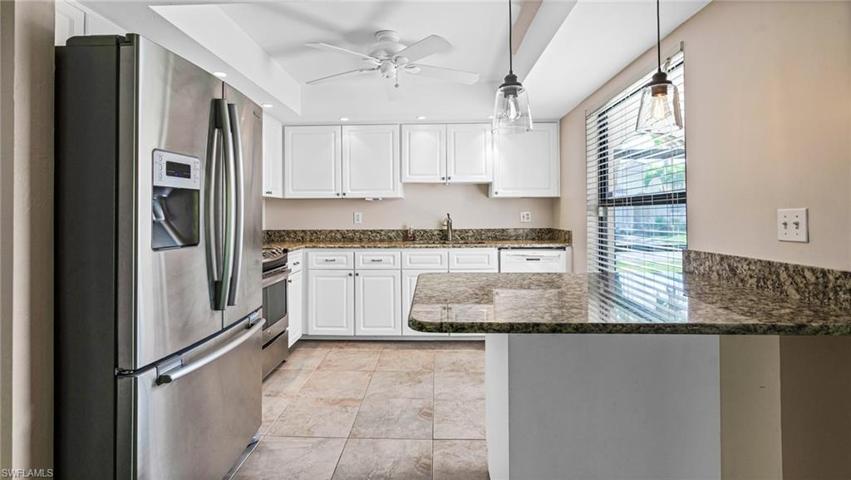 Kitchen featuring beautiful stainless appliances, white cabinets, granite and recessed lighting.