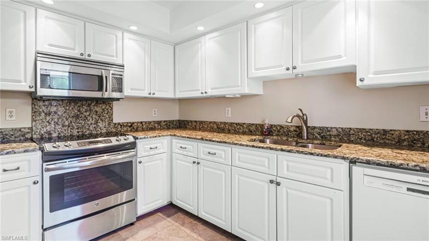 Kitchen featuring beautiful stainless appliances, white cabinets, granite and recessed lighting.