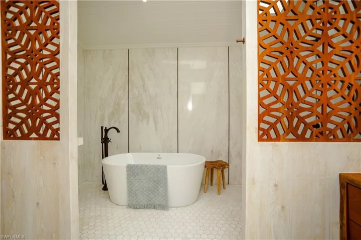 Full bath featuring a soaking tub, vanity, and tile patterned floors